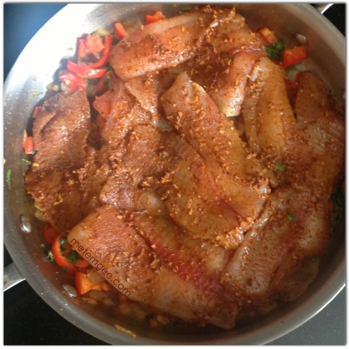 Add seasoned tilapia to the top of the cooked seasoning. Reduce heat, cover and let steam for about 5 minutes. 